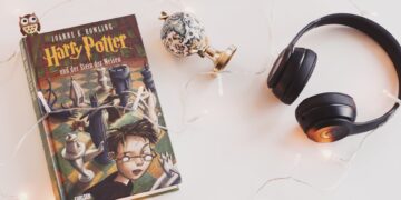 harry potter book and black headphones with trinket